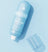 Blue bottle of "The Cooler" daily soothing spray on a matching blue background with its translucent cap off to the side.