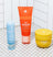 Blue daily soothing spray, orange grooming exfoliator scrub tube, and yellow ingrown hair eliminator pads on white tiled floor.