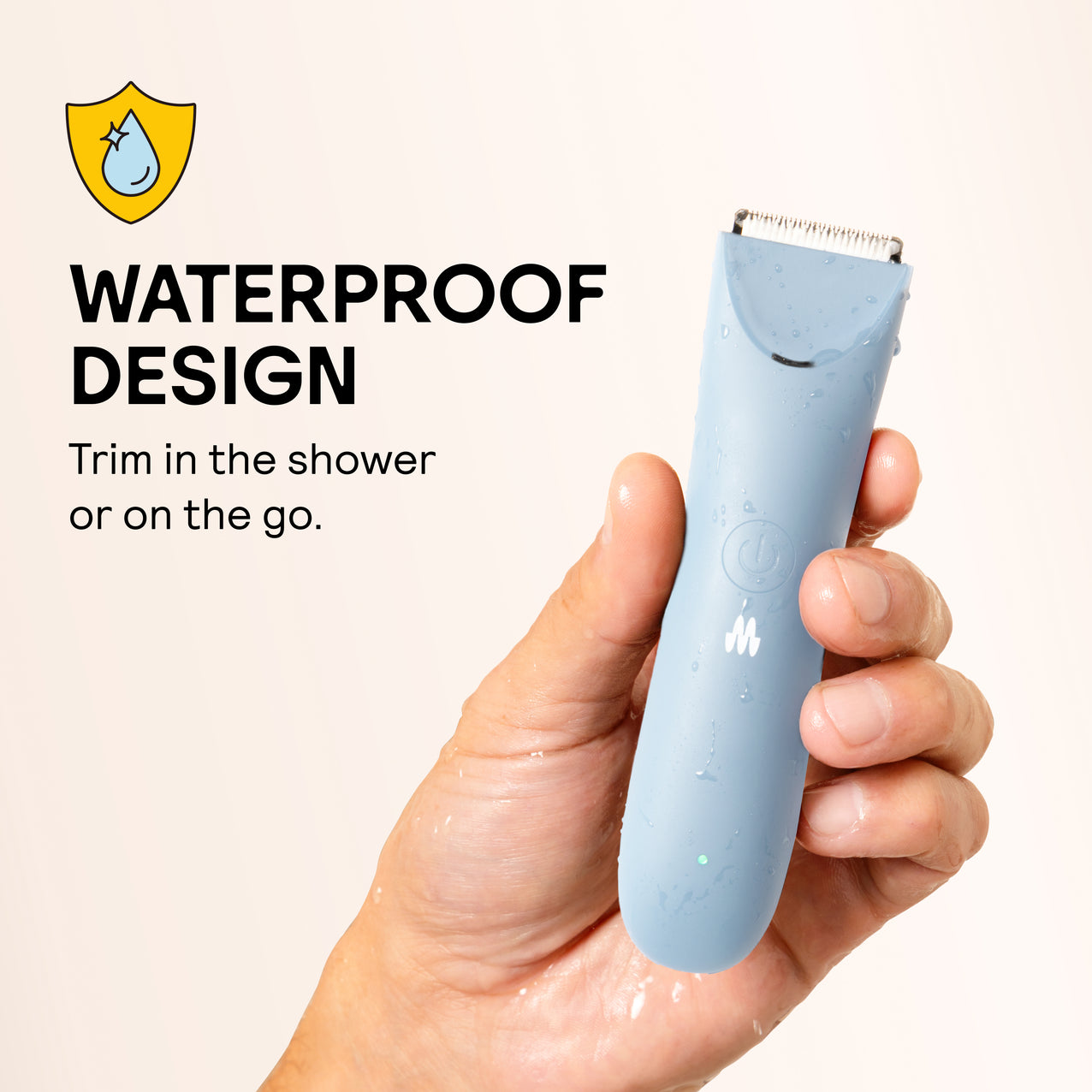 Wet hand holding blue waterproof electric hair trimmer with water droplets, waterproof design for shower trimming.