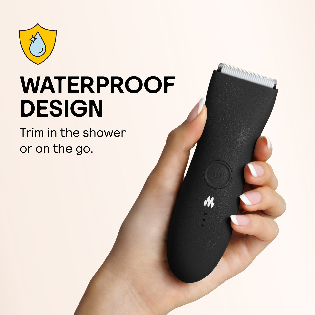Black waterproof electric trimmer with water droplets held in hand, designed for shower and travel use.