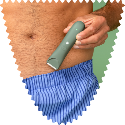 Man using a green electric hair trimmer to groom chest hair, wearing blue striped swim shorts against green background.