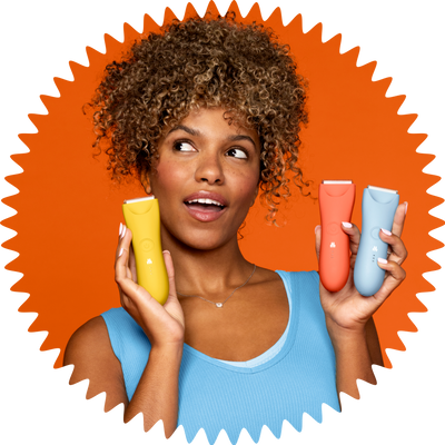Woman with curly hair holding colorful skincare or haircare product tubes wearing blue tank top on orange background