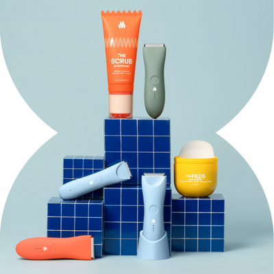 Assorted skincare products including serum, cream, and applicator devices displayed on blue grid-patterned blocks against gray background