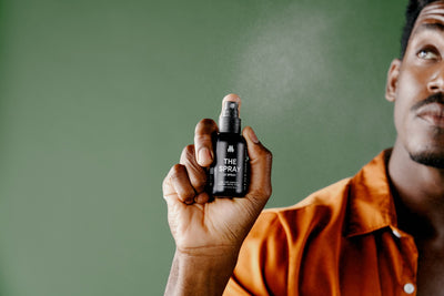 Man holding and spraying Meridian’s The Spray — a pH-balanced, deodorizing spray