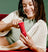 Woman holding a red hair trimmer with a green background