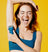 Young woman wearing blue sports bra using electric trimmer to shave underarm against bright yellow background