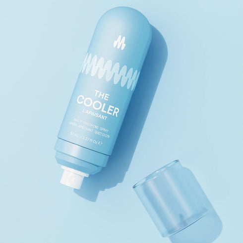 Light blue reusable water bottle labeled "THE COOLER" with matching cap on pastel blue background