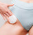 Woman in light blue underwear applying white cream on thigh with cotton pad, skincare routine, smooth skin care treatment