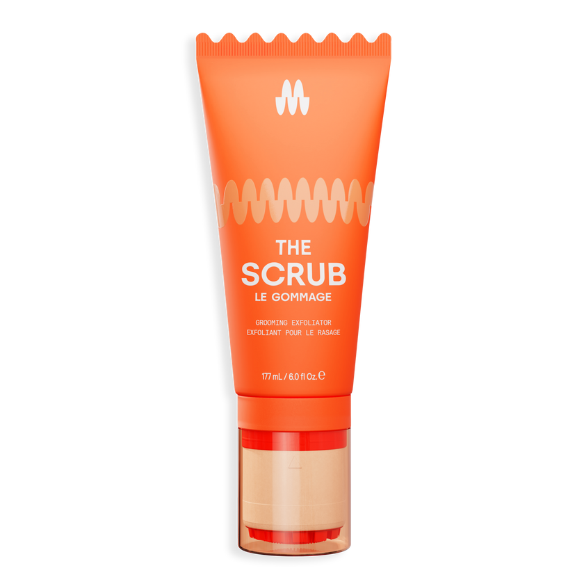 Orange exfoliating face scrub tube with gold and beige pump, labeled "The Scrub" for gentle skin renewal and detox.