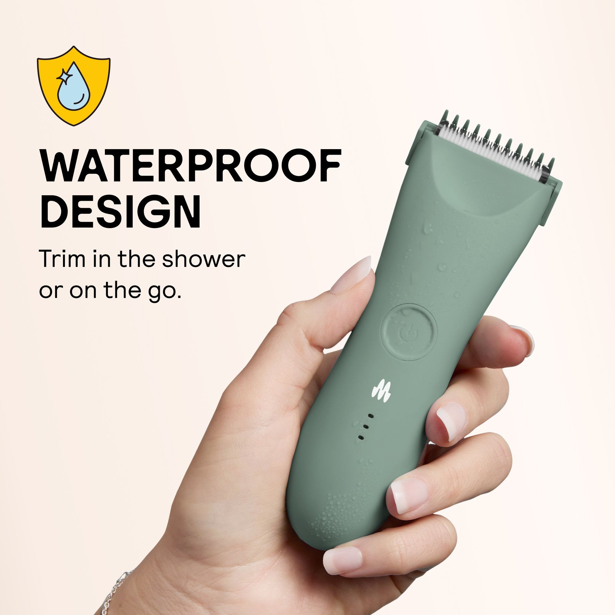 Hand holding waterproof green electric hair trimmer with water droplets, highlighting shower-safe grooming design.