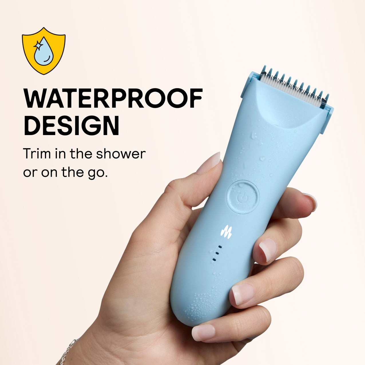 Waterproof blue electric hair trimmer held in hand with water droplets, suitable for shower and travel use.