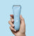 Ergonomic light blue cordless electric hair trimmer with power button and LED indicator held in hand on blue background