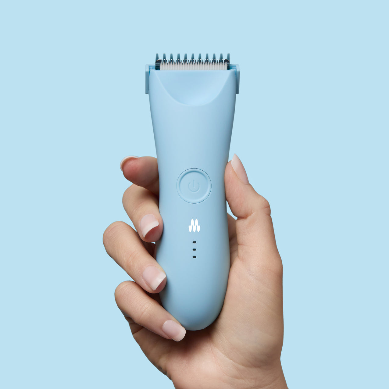Ergonomic light blue cordless electric hair trimmer with power button and LED indicator held in hand on blue background