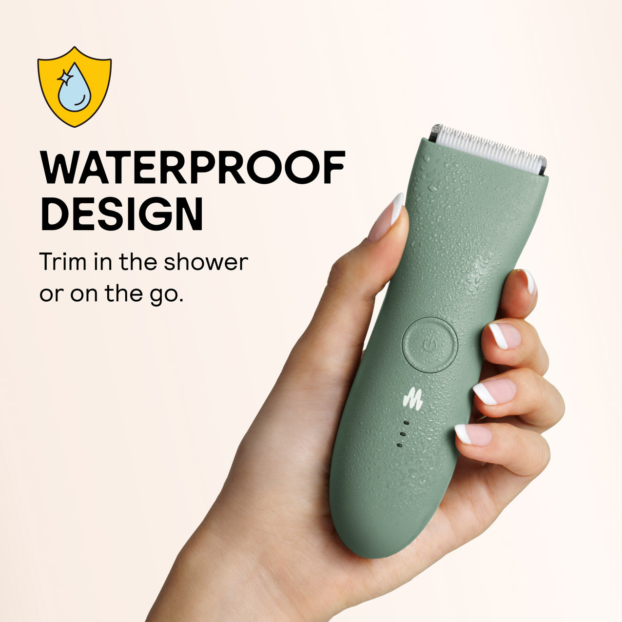 Green waterproof electric hair trimmer with water droplets held in hand, ideal for shower or travel grooming.