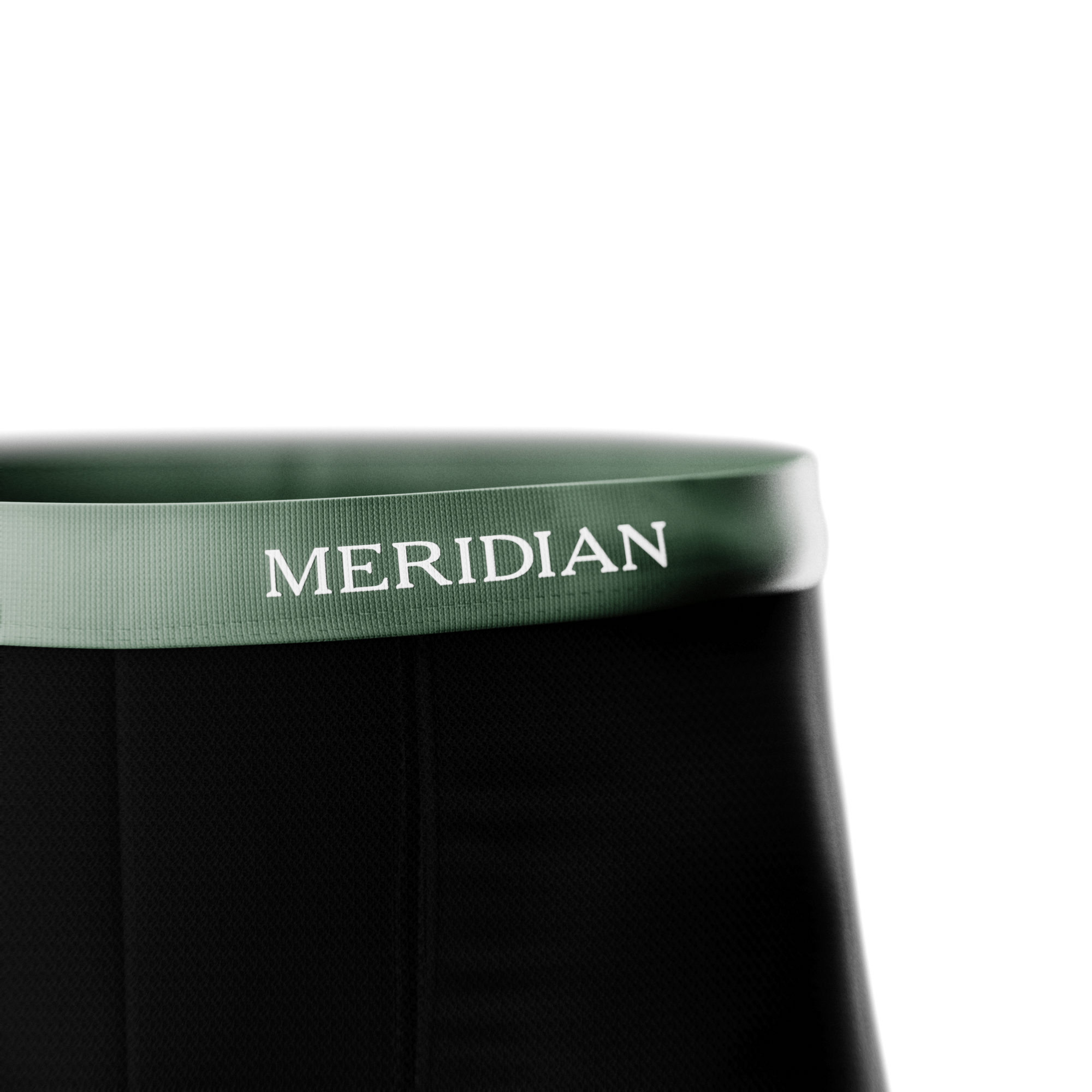 Close-up of black fabric with a green waistband featuring the "MERIDIAN" brand name in white letters.